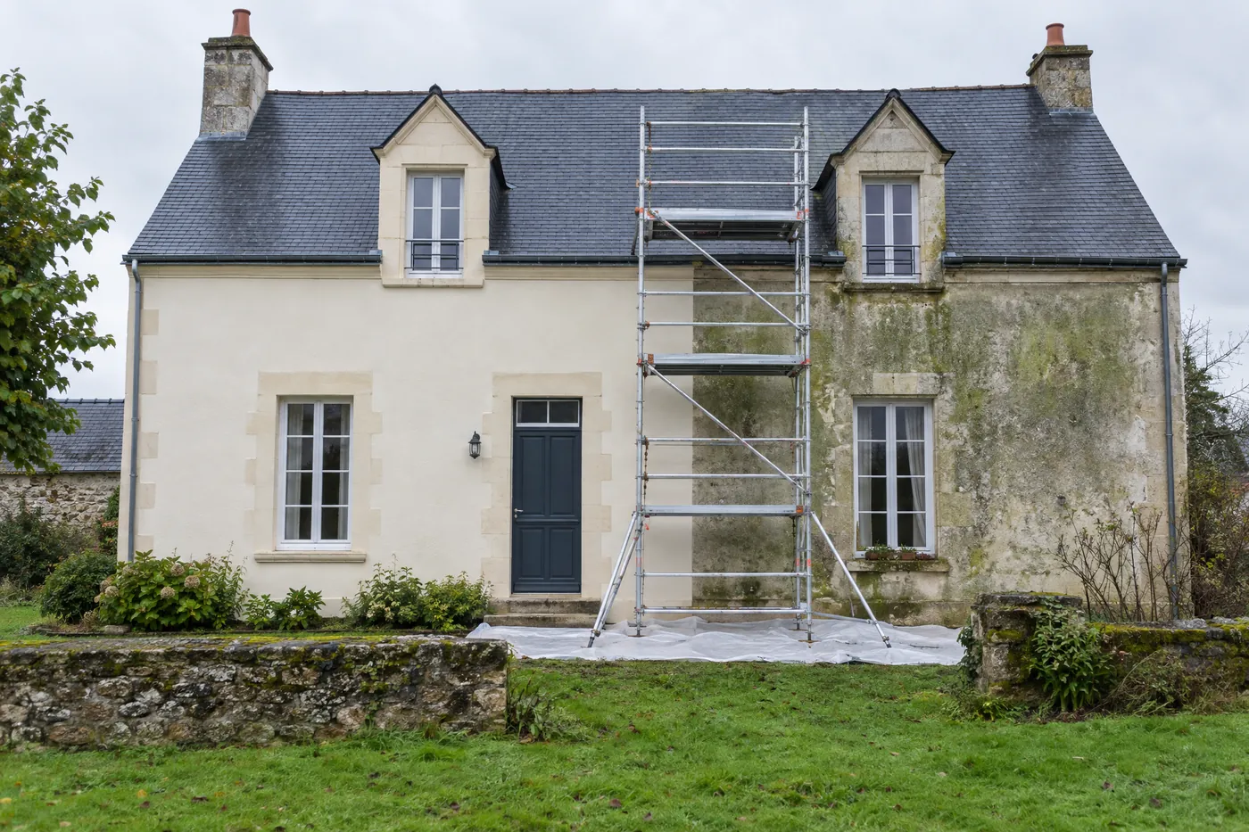Ravalement de façade en cours sur une maison ligérienne, moitié rénovée moitié ancienne